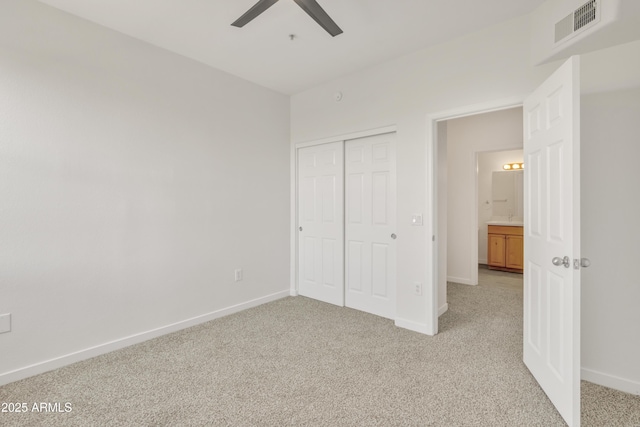 unfurnished bedroom with light carpet, ceiling fan, and a closet