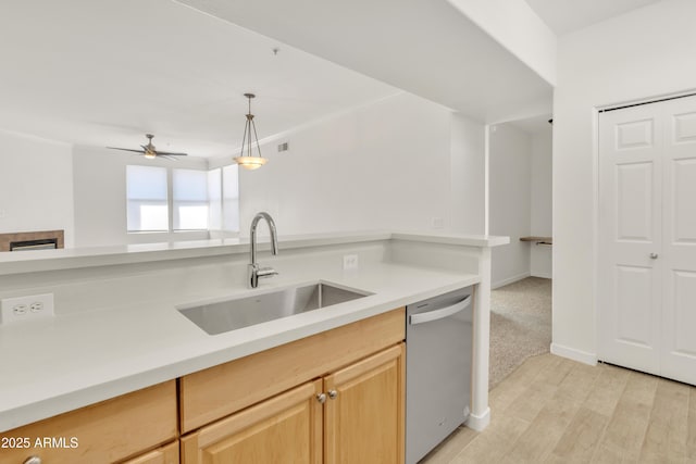 kitchen with pendant lighting, light brown cabinetry, sink, stainless steel dishwasher, and light hardwood / wood-style floors