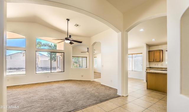17617 W Corrine Dr, Surprise, AZ 85388 - unfurnished room featuring a ceiling fan, light carpet, light tile patterned floors, arched walkways, and lofted ceiling