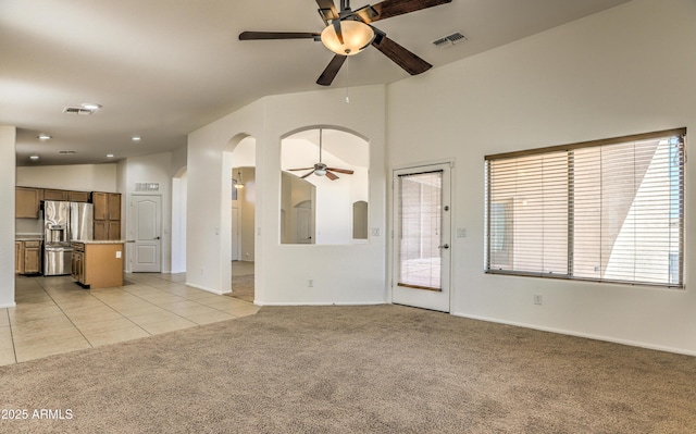 17617 W Corrine Dr, Surprise, AZ 85388 - unfurnished living room featuring ceiling fan, arched walkways, light carpet, vaulted ceiling, and baseboards