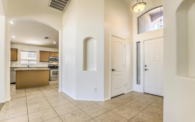 17617 W Corrine Dr, Surprise, AZ 85388 - foyer entrance featuring arched walkways, light tile patterned flooring, a high ceiling, baseboards, and recessed lighting