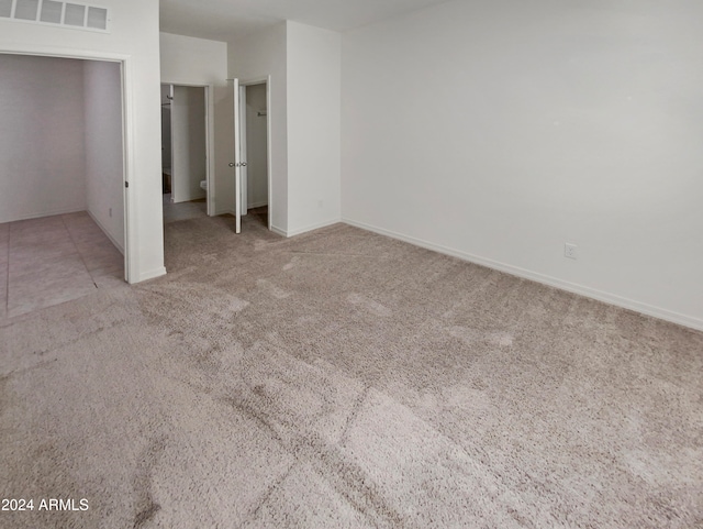 unfurnished bedroom featuring a closet and light colored carpet