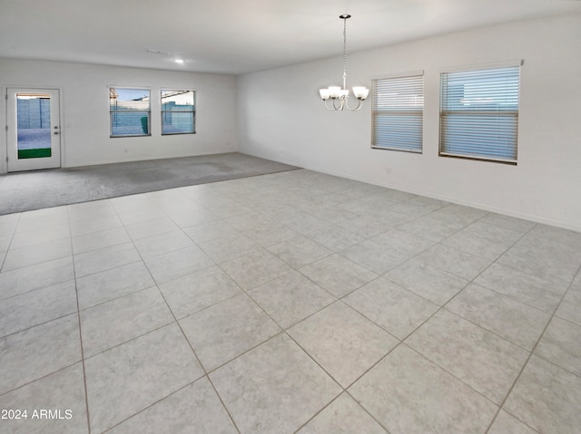 unfurnished room with plenty of natural light, light tile patterned flooring, and a chandelier