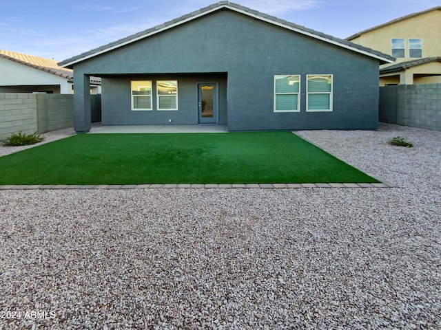 back of house with a patio area and a lawn