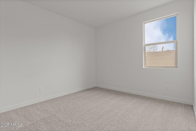 empty room featuring carpet floors and baseboards