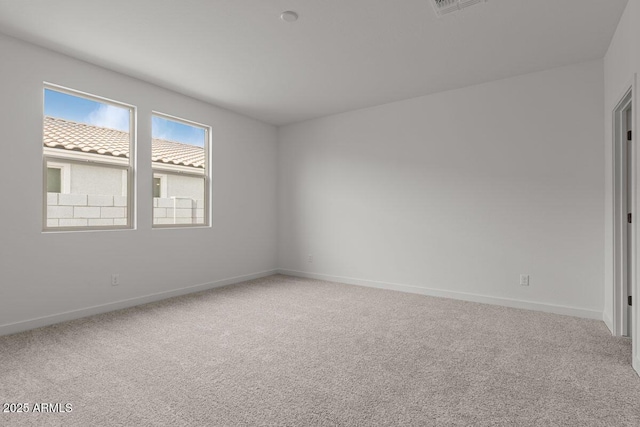 carpeted empty room featuring visible vents and baseboards