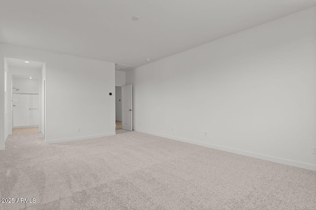 unfurnished room with light colored carpet and baseboards