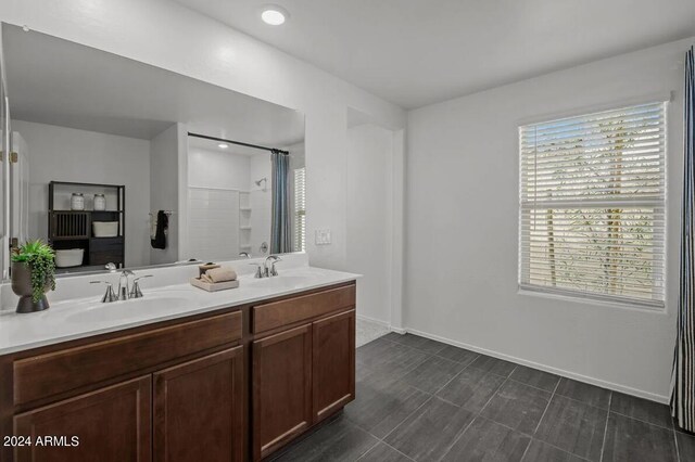 full bathroom featuring double vanity, baseboards, a sink, and a shower with shower curtain