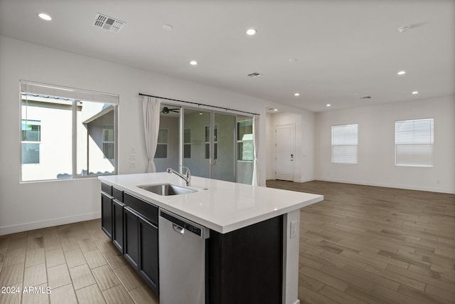 kitchen with an island with sink, a wealth of natural light, sink, and stainless steel dishwasher