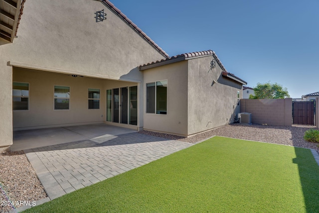 back of property featuring a patio, a yard, and central AC unit