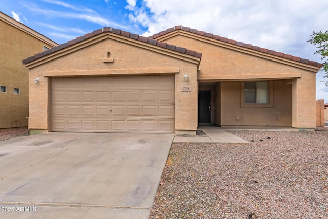 3728 W Fremont Rd, Phoenix, AZ 85041 - view of front of home featuring an attached garage, concrete driveway, and stucco siding