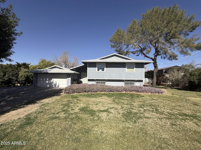 tri-level home featuring a front yard, driveway, and an attached garage