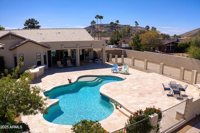 view of pool featuring a mountain view, fence, a fenced in pool, and a patio area