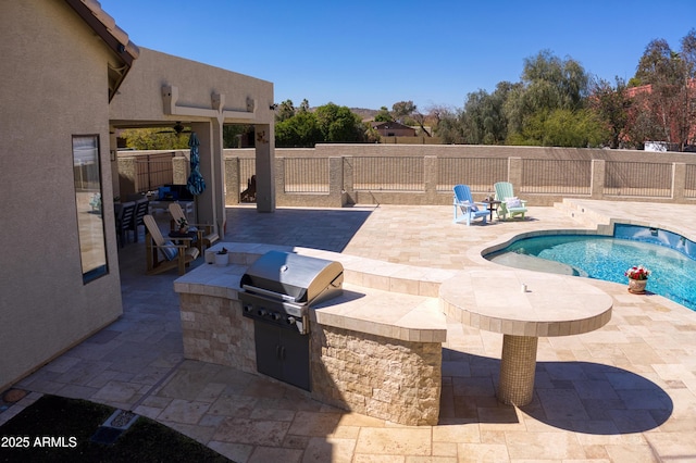 view of swimming pool featuring a fenced in pool, an outdoor kitchen, a fenced backyard, grilling area, and a patio area