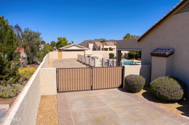 view of patio / terrace with a fenced in pool, a residential view, fence, and a gate