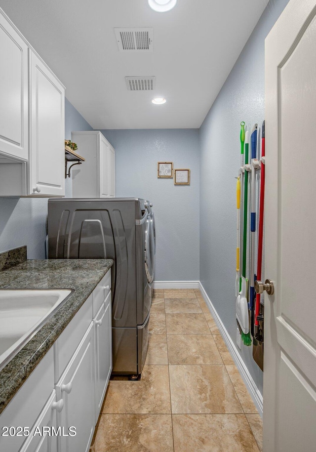 laundry room featuring visible vents, baseboards, light tile patterned floors, cabinet space, and independent washer and dryer