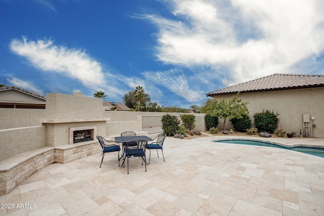 view of patio with a fenced in pool, a fenced backyard, and an outdoor fireplace