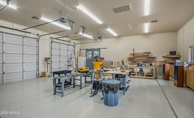 garage with visible vents, a workshop area, and a garage door opener