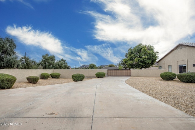 view of patio / terrace with a fenced front yard, concrete driveway, and a gate