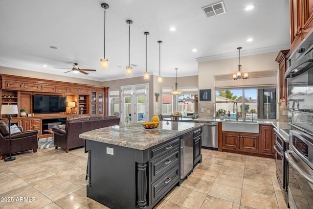 kitchen with a wealth of natural light, beverage cooler, ornamental molding, a sink, and stainless steel appliances