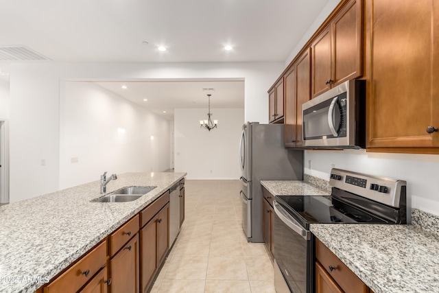 kitchen featuring light stone counters, sink, light tile patterned flooring, a chandelier, and appliances with stainless steel finishes