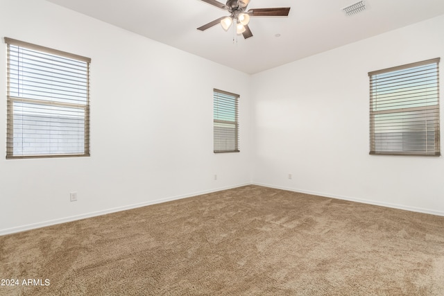 carpeted spare room with ceiling fan