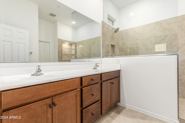 bathroom featuring a tile shower, tile patterned floors, and vanity