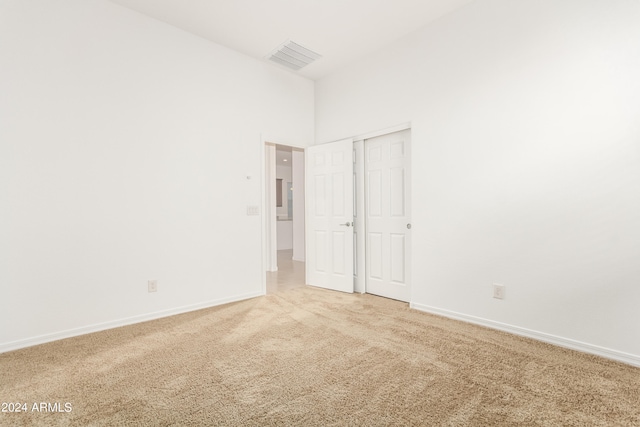 carpeted spare room with a high ceiling