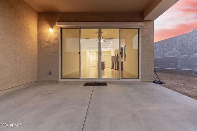 exterior entry at dusk featuring a patio