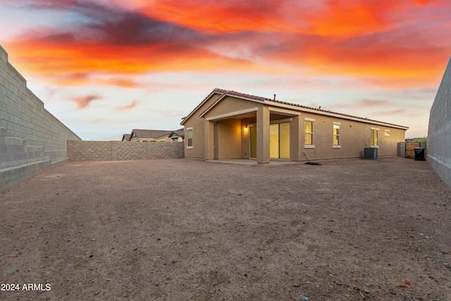 back house at dusk featuring central AC unit