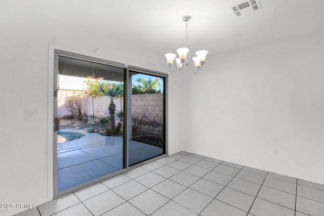 spare room with light tile patterned flooring and a chandelier