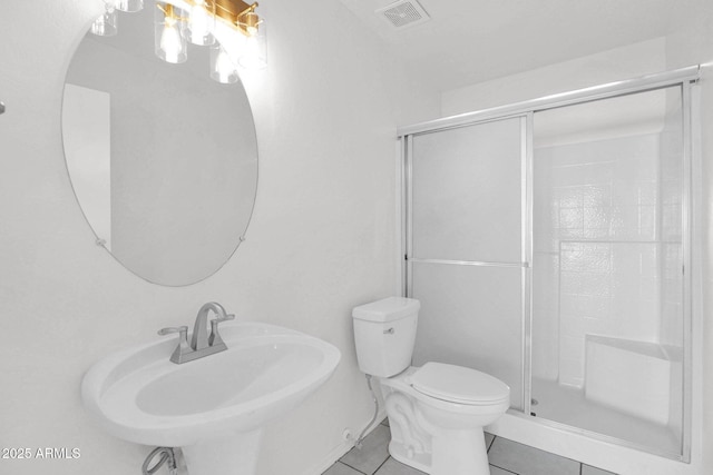 bathroom with walk in shower, sink, tile patterned floors, and toilet