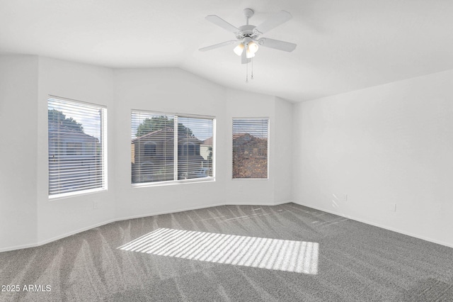 carpeted empty room with vaulted ceiling and ceiling fan