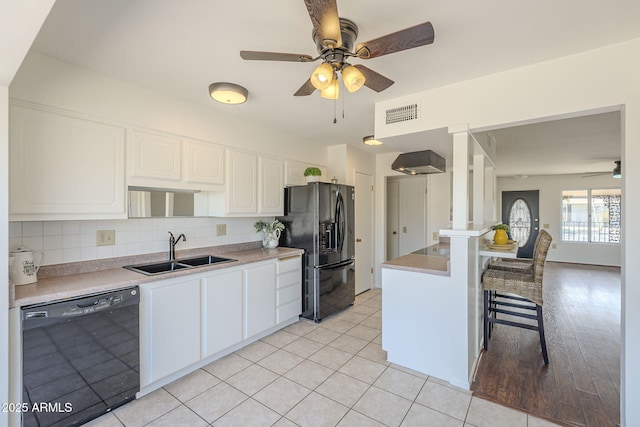 kitchen with visible vents, black appliances, a sink, backsplash, and white cabinetry