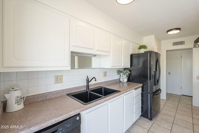 kitchen with light tile patterned floors, visible vents, a sink, white cabinetry, and tasteful backsplash