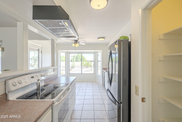 kitchen featuring a ceiling fan, freestanding refrigerator, white electric stove, light tile patterned floors, and extractor fan