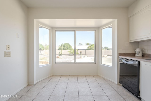 unfurnished dining area featuring light tile patterned floors and baseboards