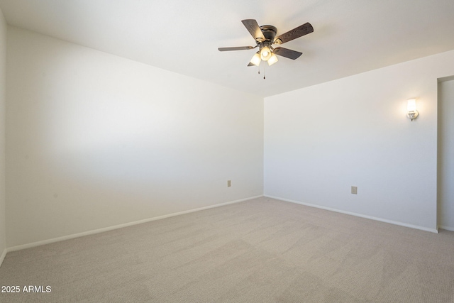 empty room featuring light colored carpet, baseboards, and ceiling fan