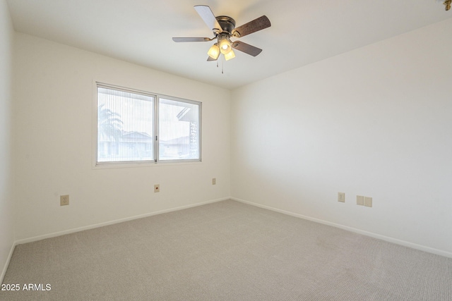 empty room featuring baseboards, light colored carpet, and a ceiling fan