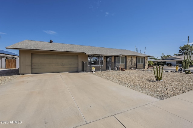 ranch-style home with driveway, an attached garage, and fence