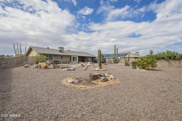 rear view of house featuring central air condition unit and a fenced backyard