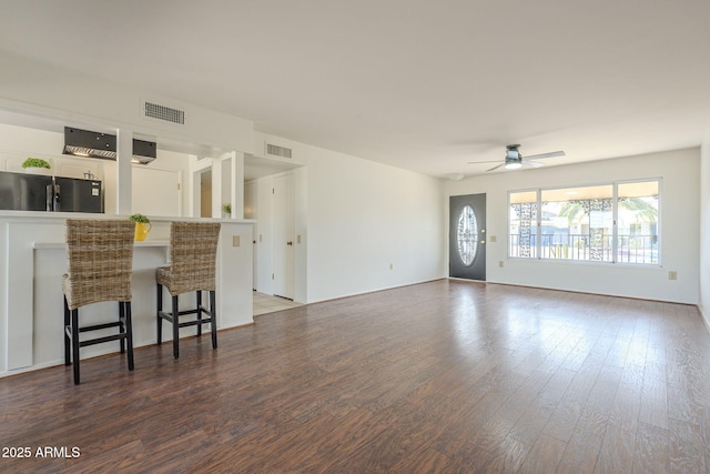 living area with a ceiling fan, wood finished floors, and visible vents