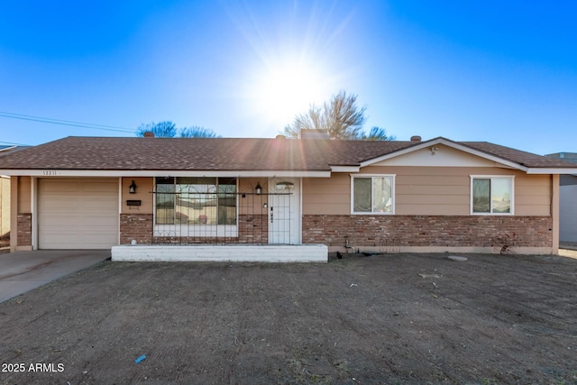 ranch-style house with a garage, concrete driveway, and brick siding