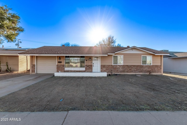 ranch-style home with a garage, driveway, and brick siding