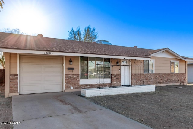 ranch-style home featuring a garage, driveway, brick siding, and a shingled roof