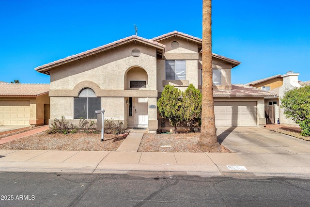 view of front of home featuring concrete driveway, a tiled roof, an attached garage, and stucco siding