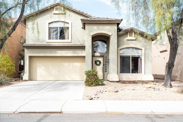 view of front facade with a garage, driveway, a tile roof, and stucco siding