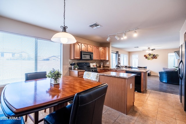 kitchen with a center island, visible vents, light tile patterned flooring, a peninsula, and black appliances