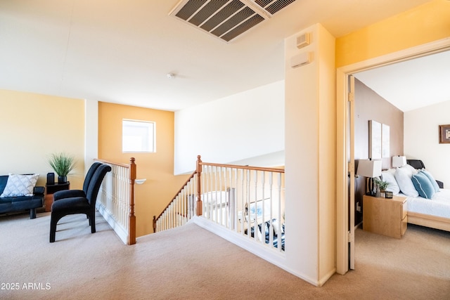 corridor featuring a healthy amount of sunlight, carpet, visible vents, and an upstairs landing