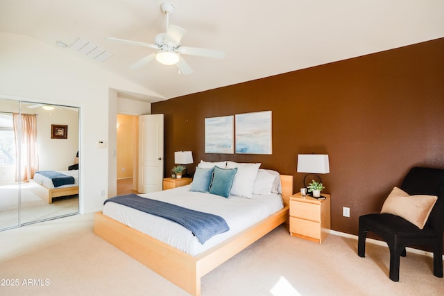 bedroom featuring light carpet, a closet, lofted ceiling, and visible vents